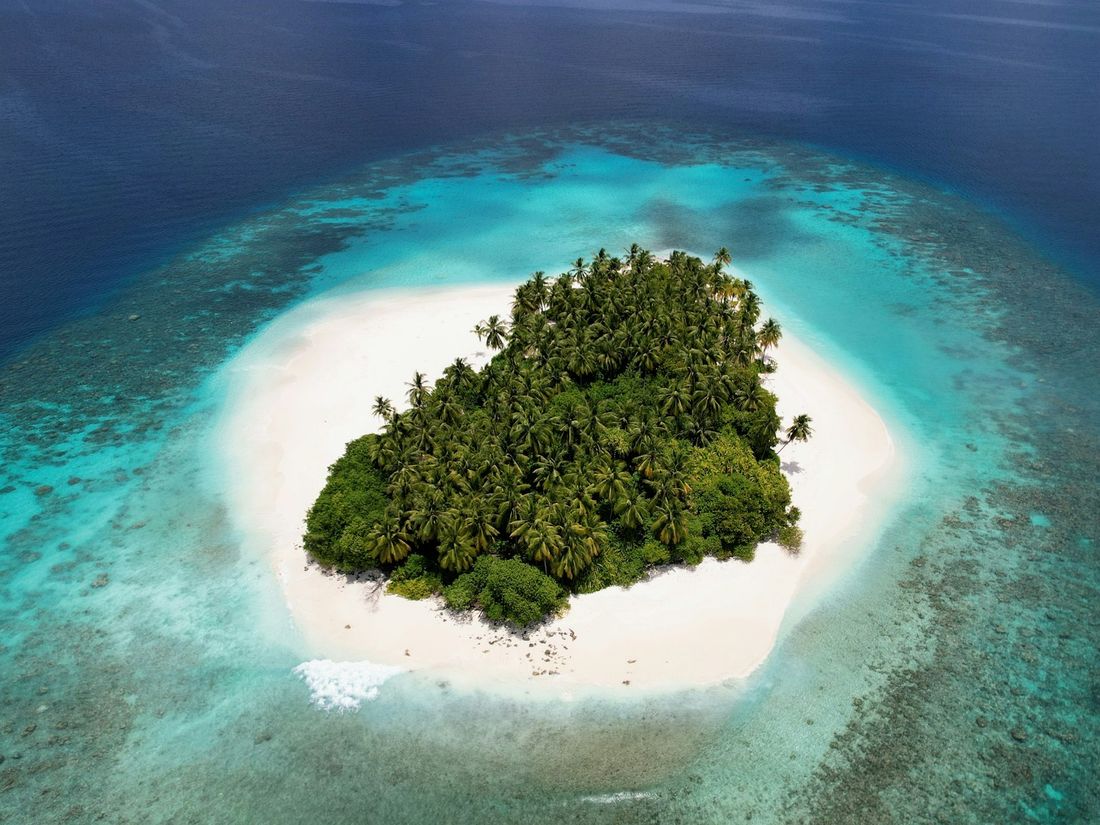 A small tropical island ringed with white sand and turquoise water.